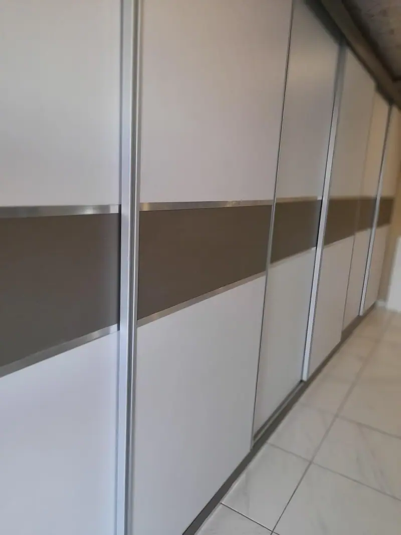 Floor-to-ceiling sliding wardrobe doors with a bronze mirror band